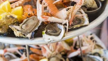 A multi-tiered seafood platter with various shellfish and lemon slices.
