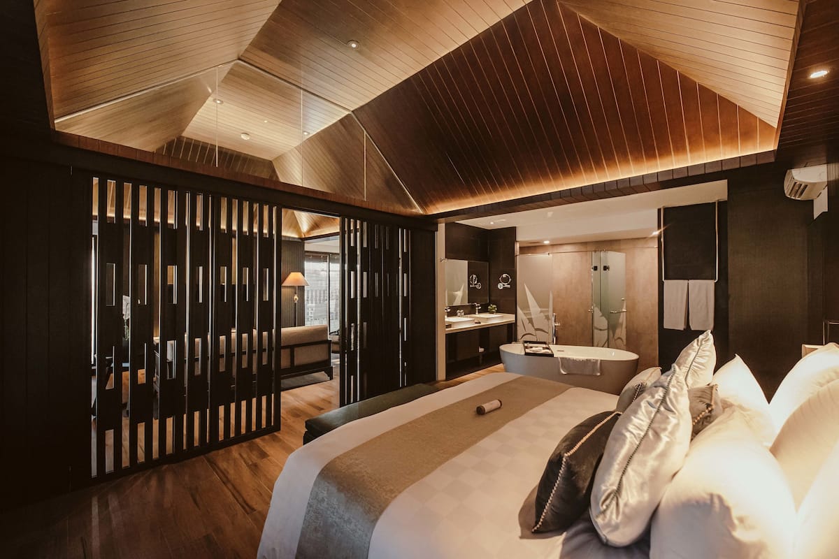 Una habitación de hotel moderna con una cama grande, un escritorio y un baño.
