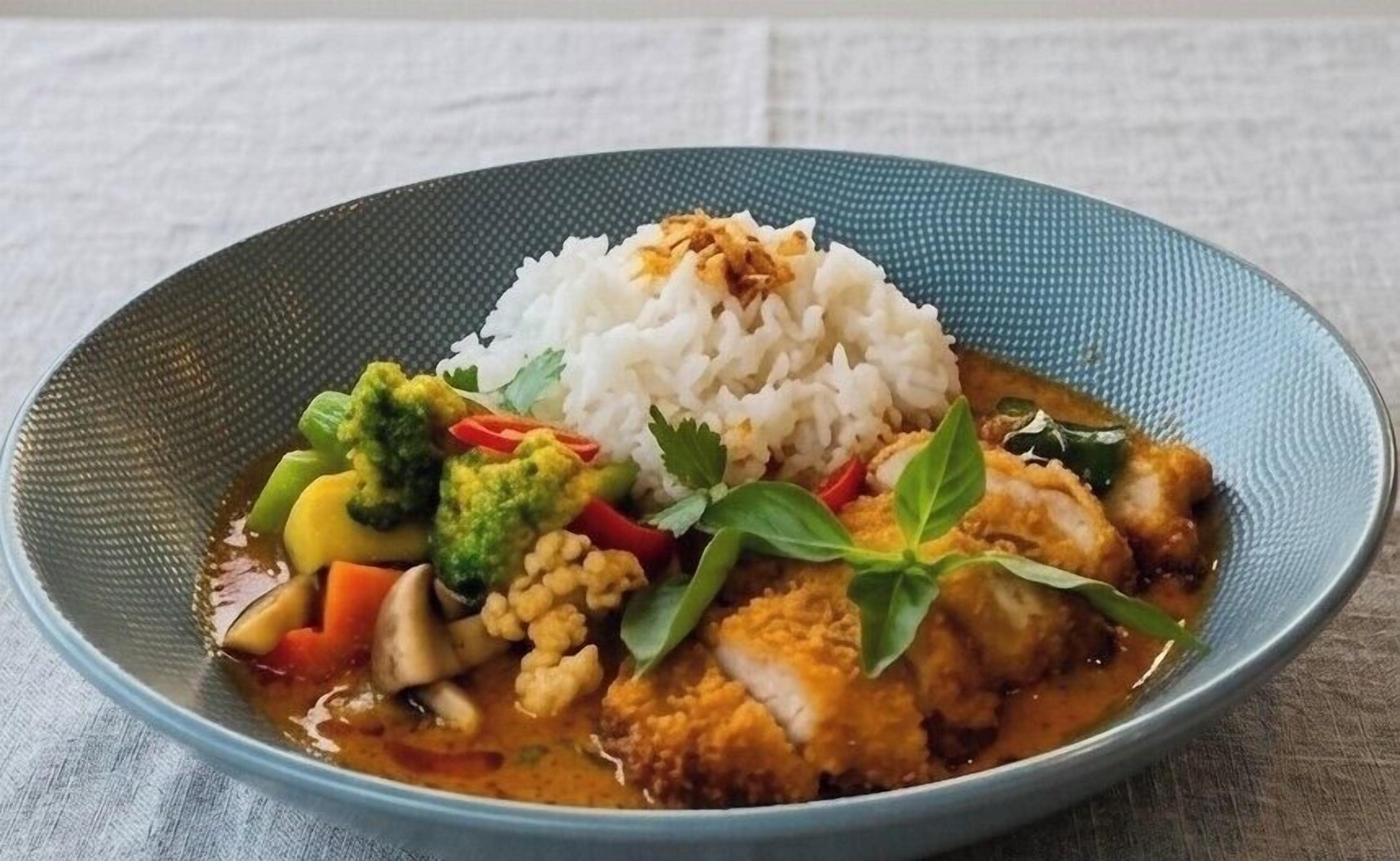A plate of food with rice, vegetables, and a piece of meat.