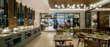 A modern dining area with a buffet setup, multiple seating arrangements, and a contemporary ceiling design.