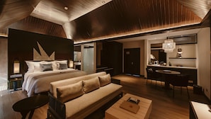 A modern hotel room with a large bed, a sofa, a dining area, and a kitchenette. - The Vira Bali Boutique Hotel & Suite (Kuta)