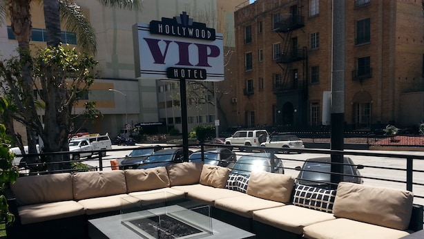 An outdoor seating area with a large sign for the Hollywood VIP Hotel. - Hollywood VIP Hotel (Los Angeles)