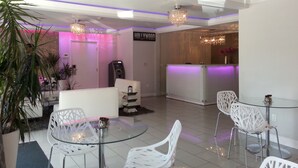 A modern hotel lobby with a reception desk, seating area, and decorative plants. - Hollywood VIP Hotel (Los Angeles)