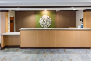 A reception desk with a modern design, a patterned wall behind it, and a tiled floor. - Fairfield Inn & Suites by Marriott Elizabethtown (Elizabethtown)