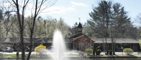 A building with a tower, a fountain, and trees.
