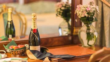 Uma mesa com uma garrafa de champanhe Moët, uma toalha dobrada e uma pequena tigela de maçãs.