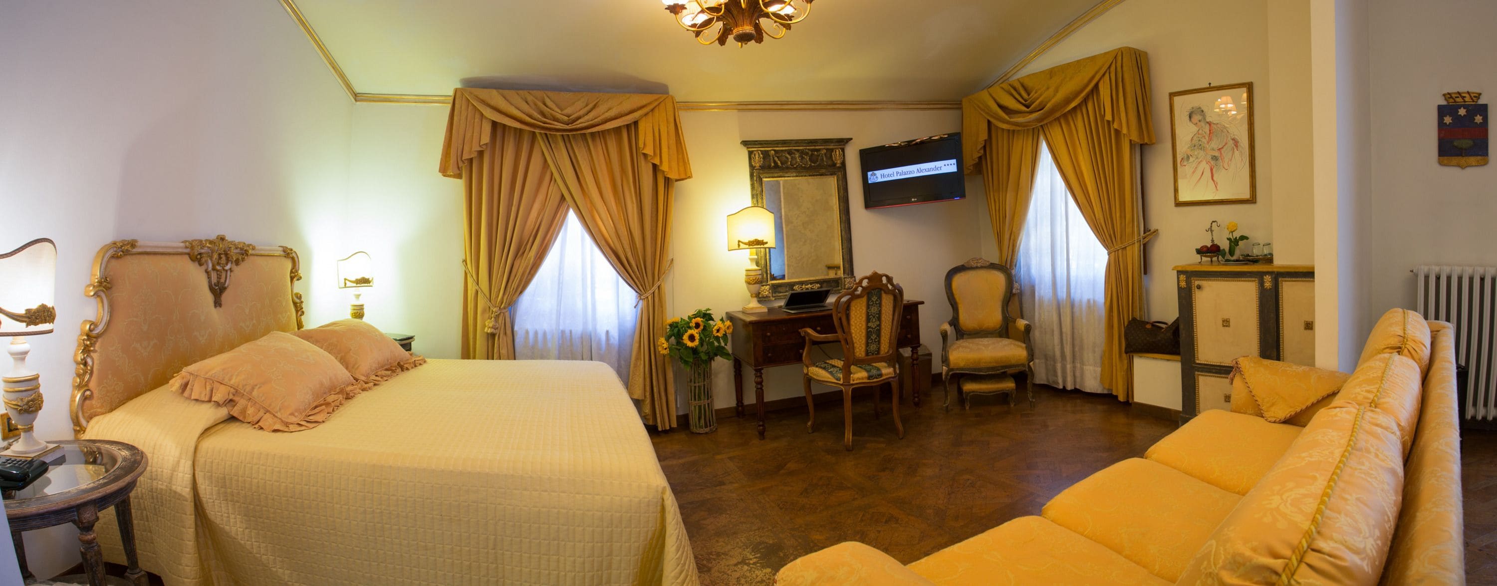 Una habitación de hotel con una cama grande, un escritorio, una silla, un sofá y una televisión.