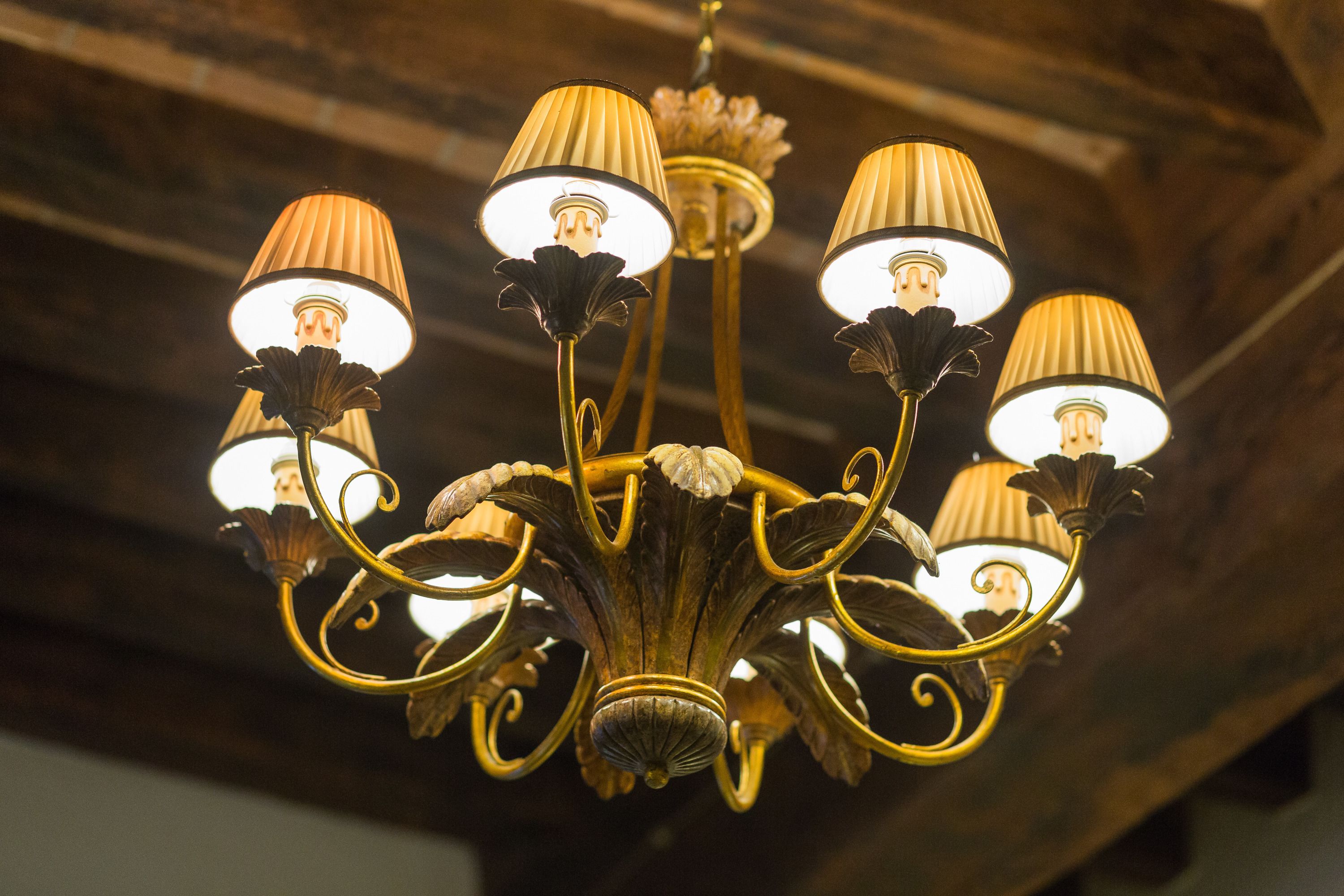 A chandelier with multiple lampshades and a decorative base.