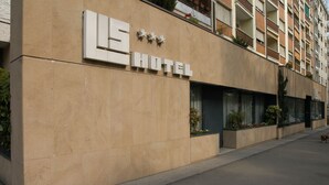 Een hotelgevel met een modern ontwerp, met een opvallend bord met drie sterren en het woord 'HOTEL' in grote letters.