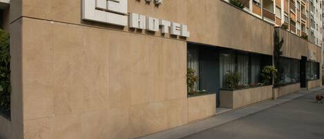 A hotel facade with a modern design, featuring a prominent sign with three stars and the word "HOTEL" in large letters.