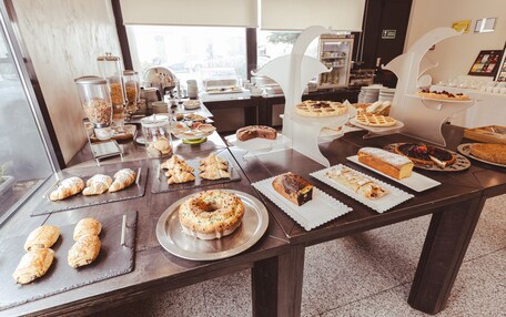 A buffet table with various pastries, cakes, and desserts.