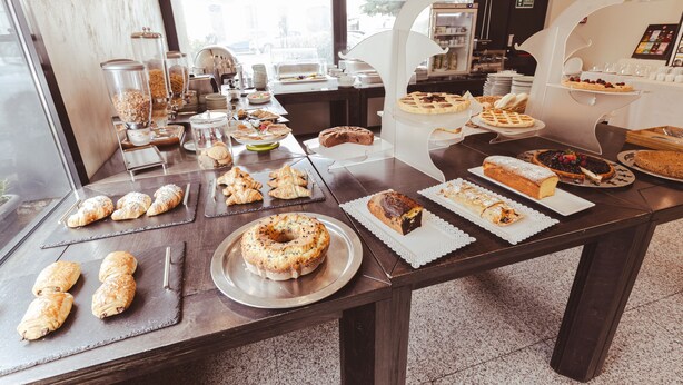 Een buffettafel met diverse gebakjes, taarten en desserts.