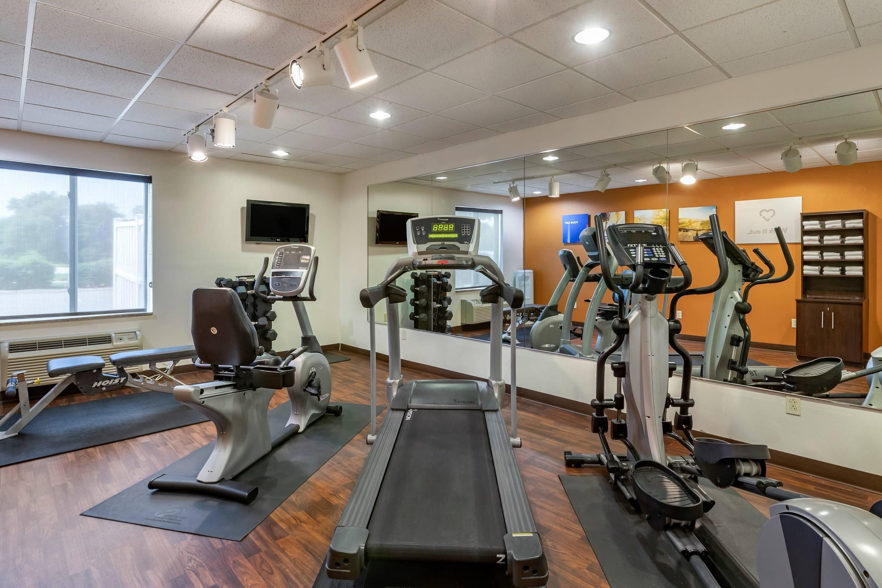 A gym with treadmills, elliptical machines, and weight equipment.