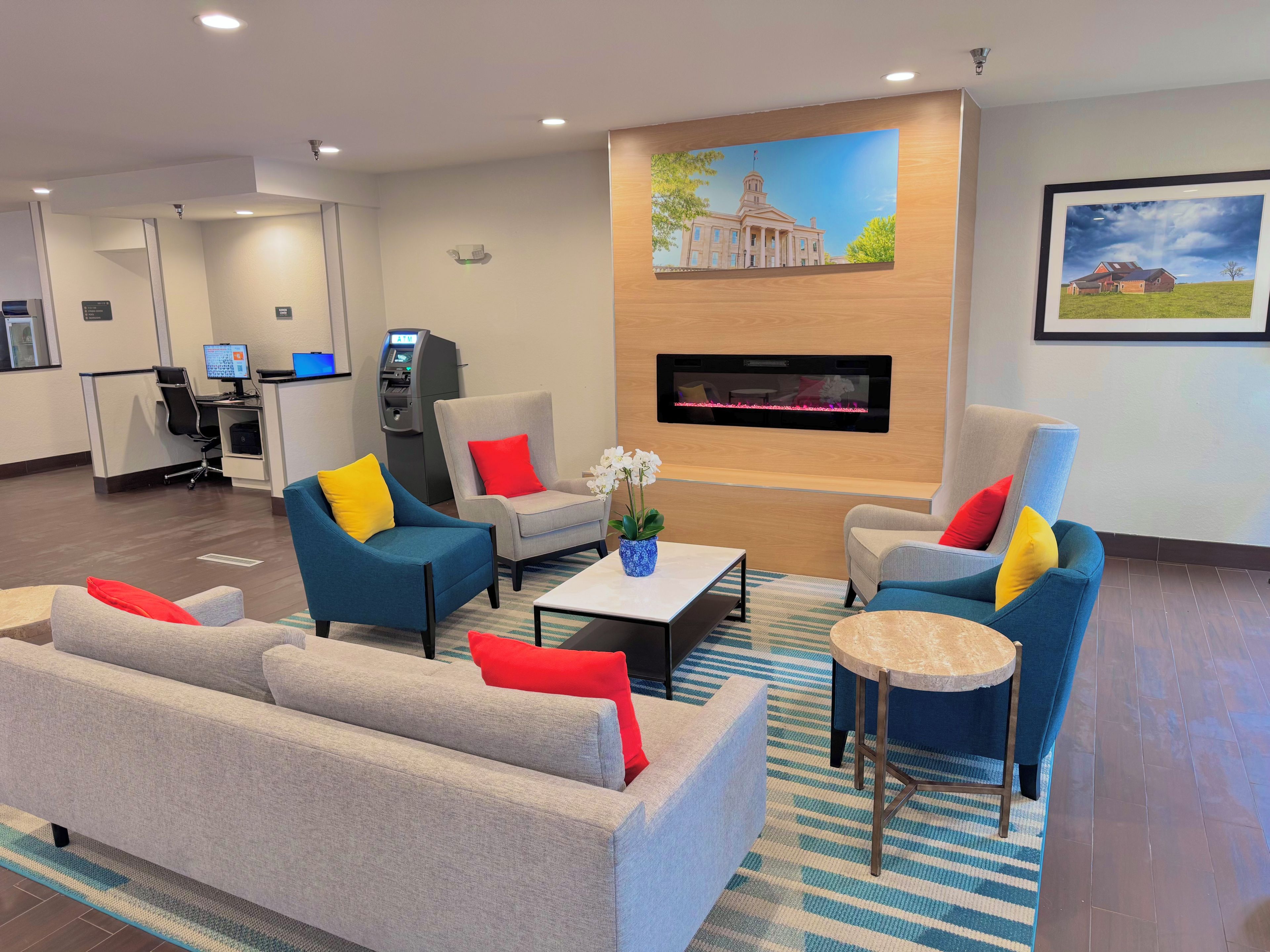 A hotel lobby with seating arrangements, a reception desk, and a fireplace.