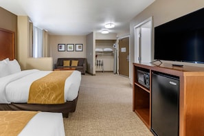A hotel room with a bed, a sofa, a television, a refrigerator, and a microwave. - Comfort Suites Coralville I-80 (Coralville)
