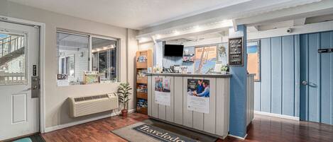 A reception area with a desk, a television, and informational posters.