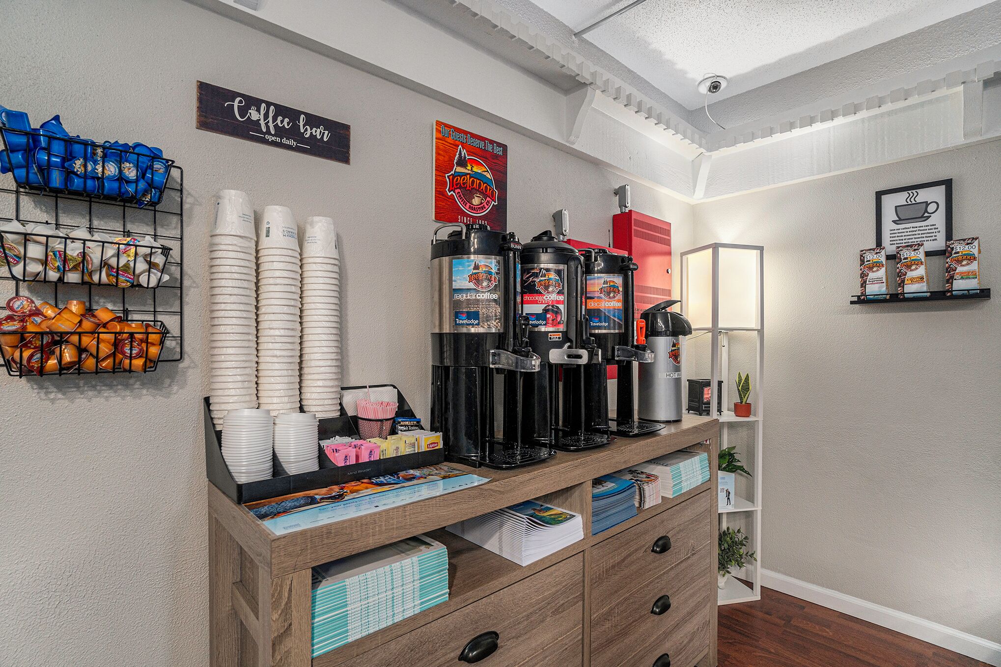 Un bar à café doté de plusieurs distributeurs de café, d’une enseigne indiquant « Bar à café », ainsi que de divers tasses et récipients à café.