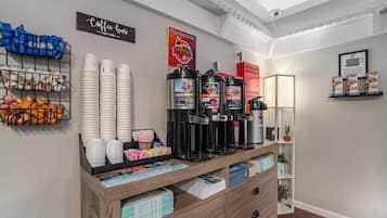 Un bar à café doté de plusieurs distributeurs de café, d’une enseigne indiquant « Bar à café », ainsi que de divers tasses et récipients à café.