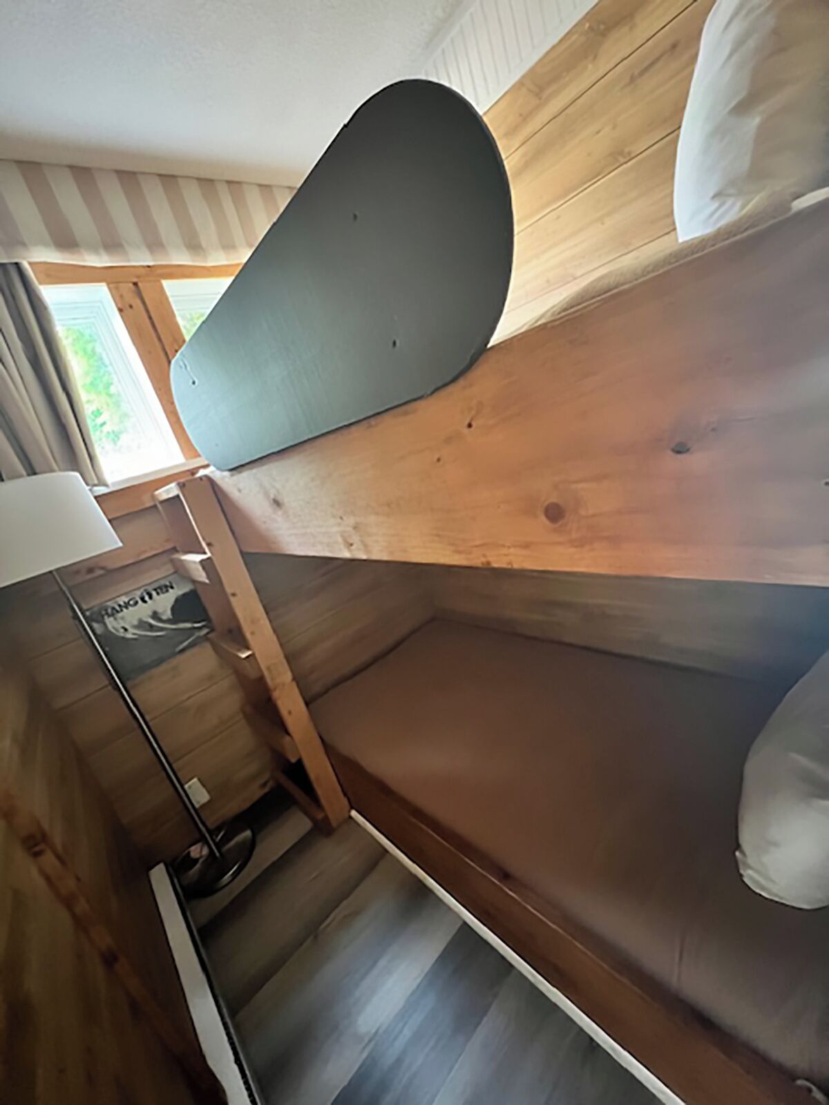 Ein Stockbett mit Kissen und Lampe.