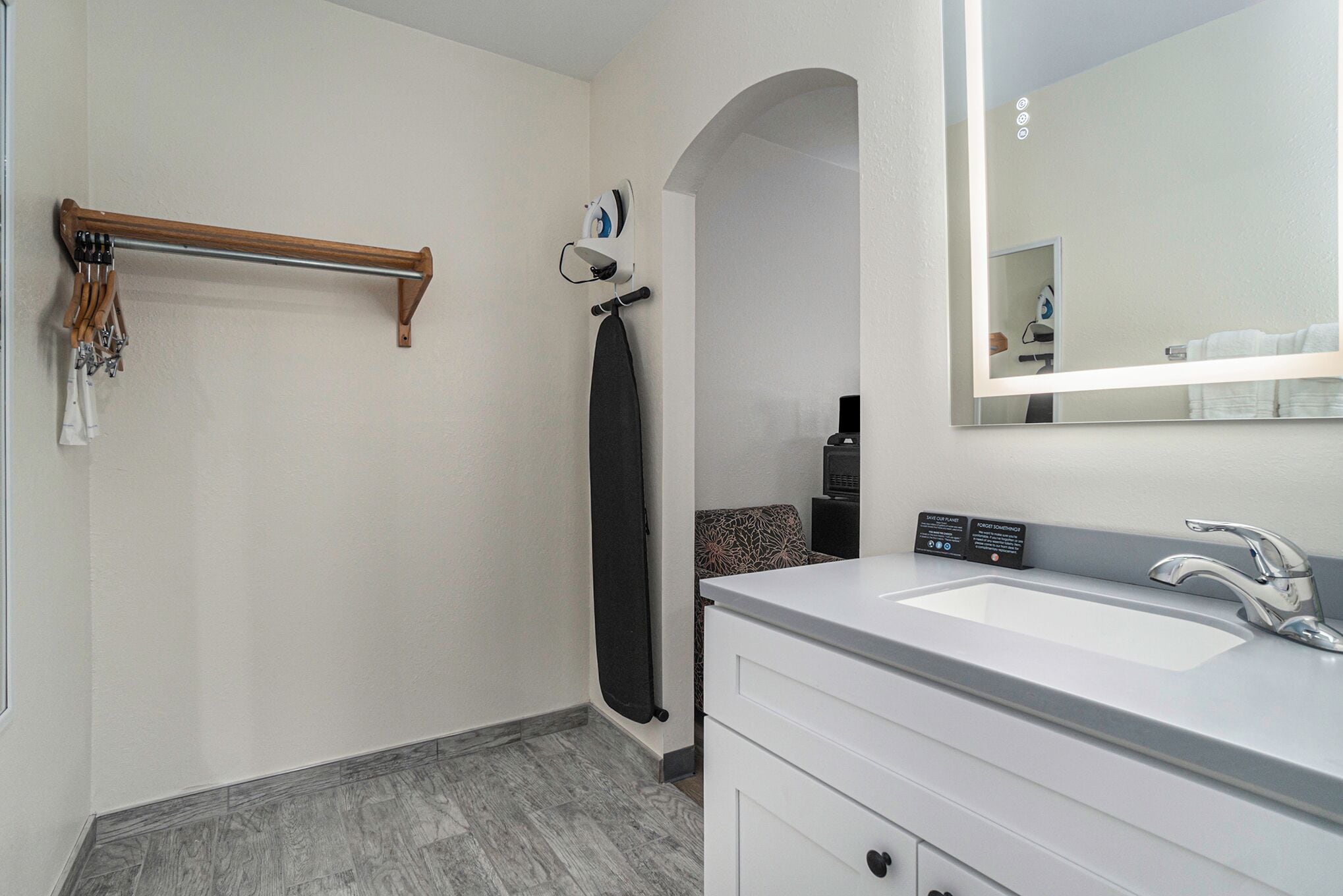 A modern bathroom with a white vanity, a large mirror, and a shower area.