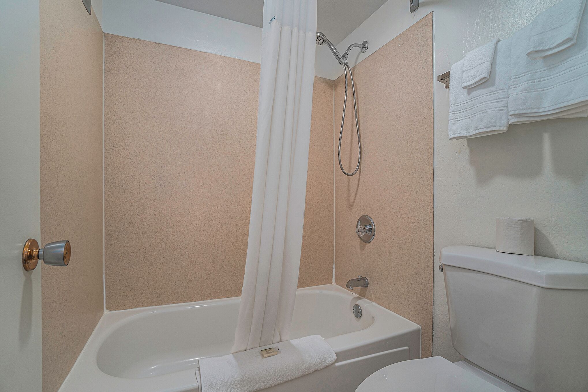 Un bagno con vasca, doccia, servizi igienici e asciugamani.