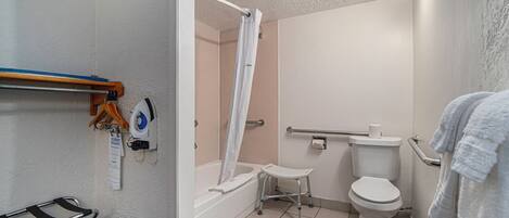 Une salle de bain avec une douche, des toilettes et un petit marchepied.