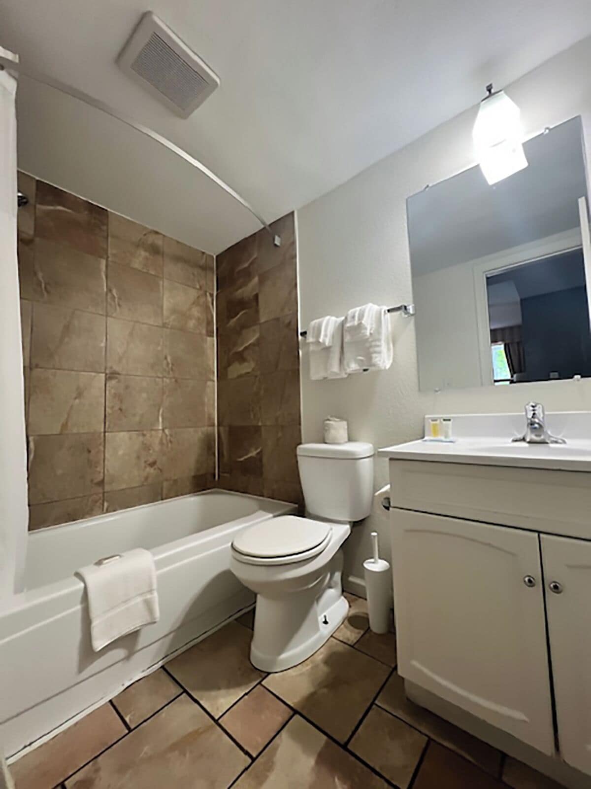 A bathroom with a bathtub, toilet, and sink.