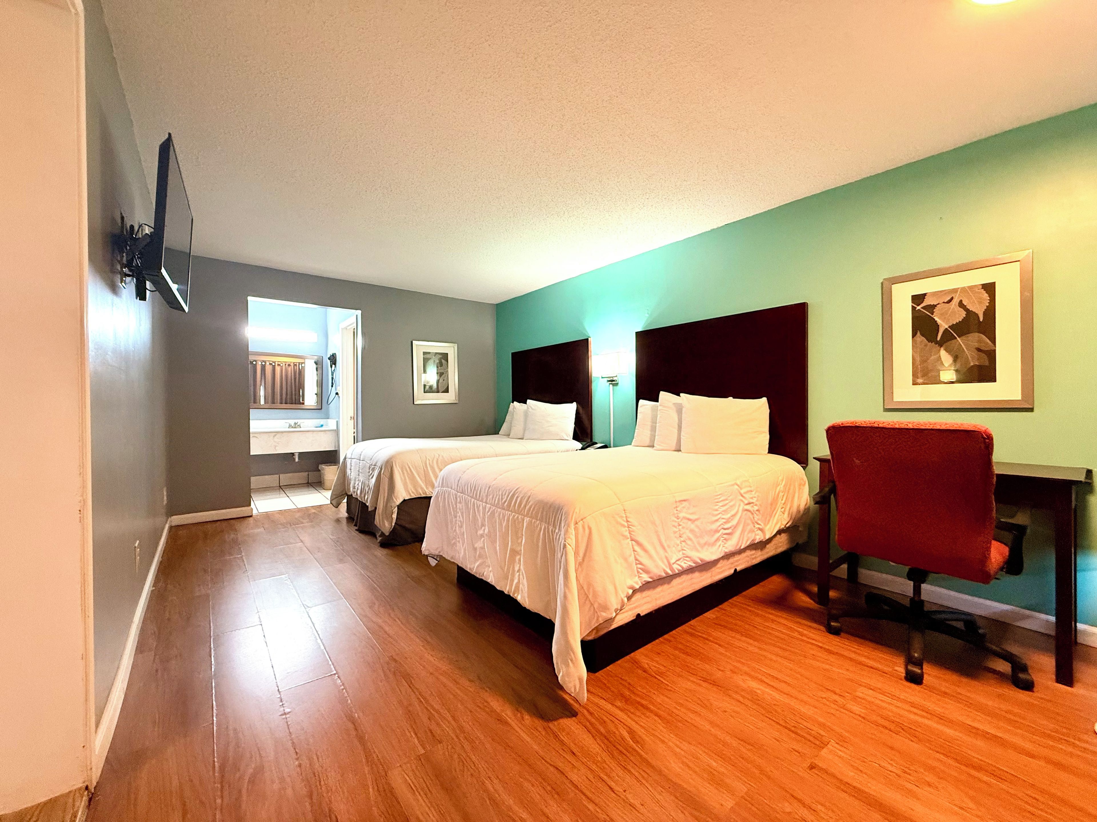 Een hotelkamer met een groot bed, een bureau en een stoel.