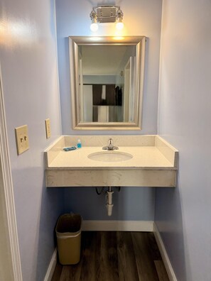 A bathroom with a sink, mirror, and light fixture. - Americas Best Value Inn Suites & Studios Blytheville by Sonesta (Blytheville)