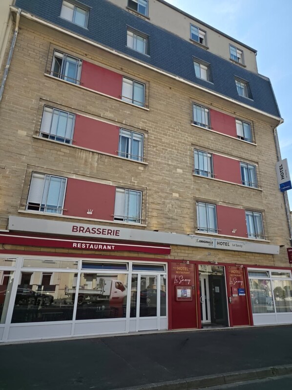 A multi-story building with a restaurant and hotel on the ground floor.