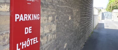 A red sign with white text indicating a 3M parking area for a hotel, with an arrow pointing to the right.