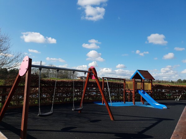 A playground with swings and a slide.