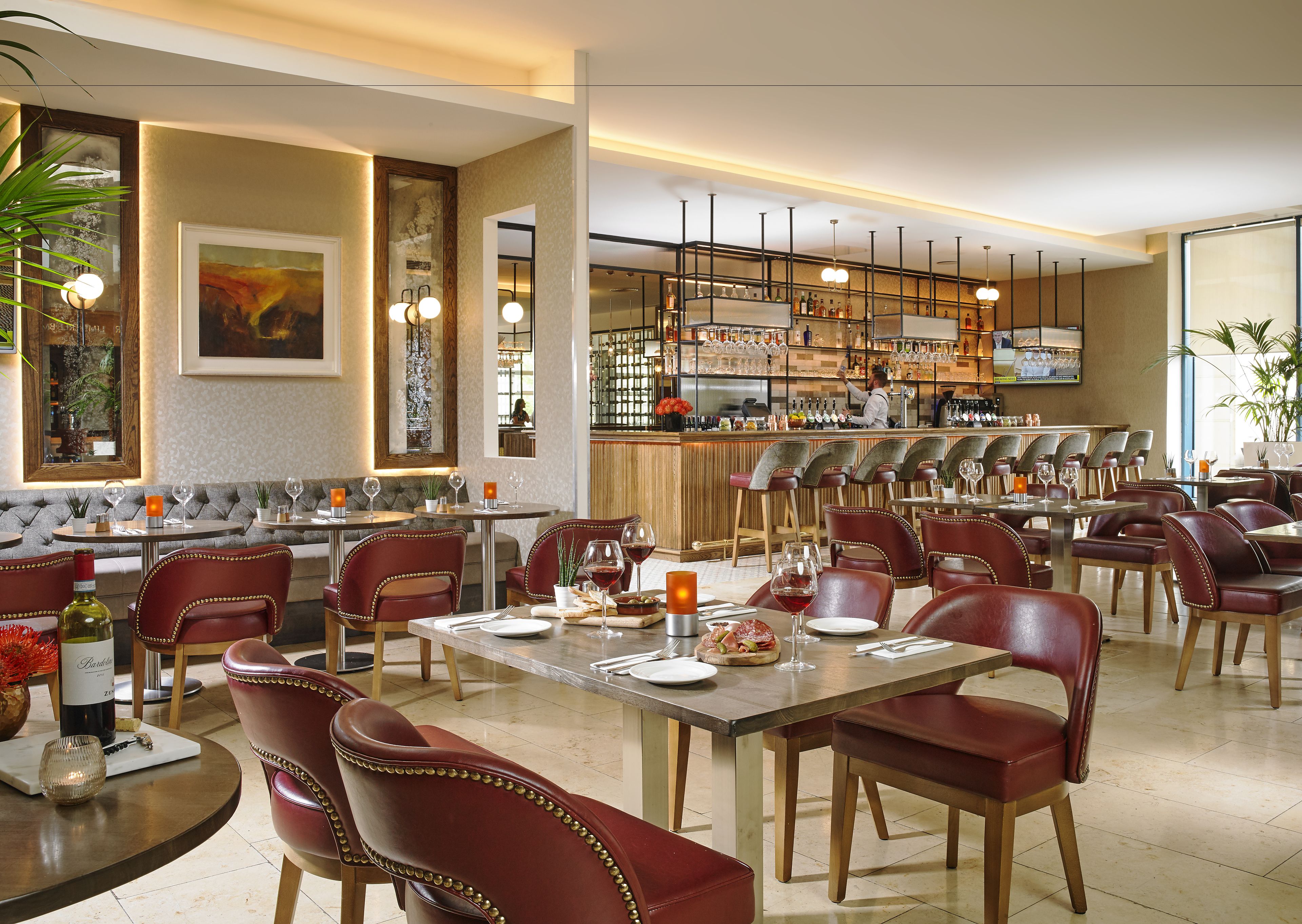A restaurant with a bar area, seating arrangements, and a bar counter.
