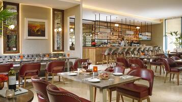 A restaurant with a bar area, seating arrangements, and a bar counter.