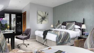 Una habitación de hotel moderna con una cama grande, un escritorio, una silla y un sofá.