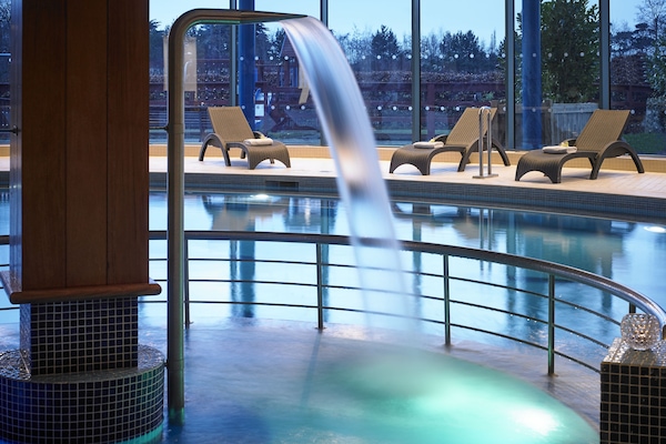 Una piscina techada, sillones reclinables de piscina