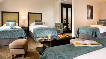 A hotel room with two beds, a sofa, a coffee table, and a chair.