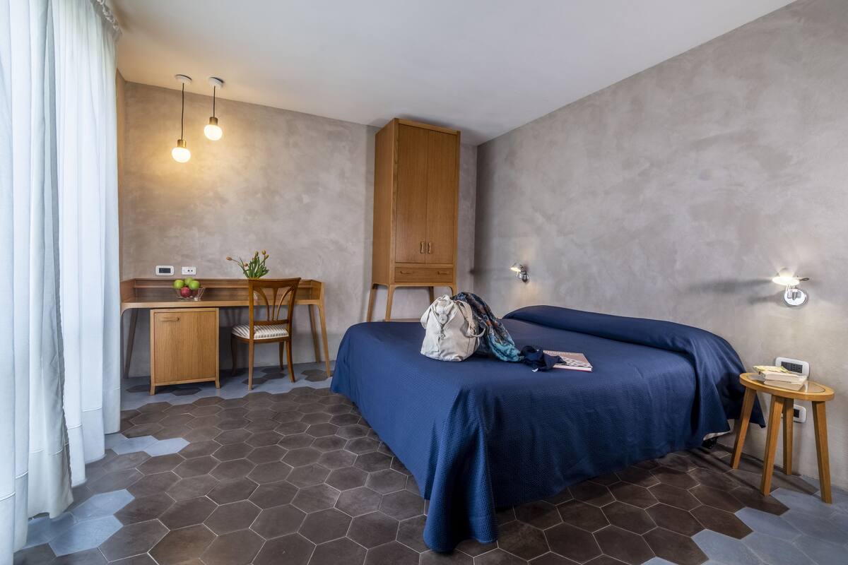 Un dormitorio con cama, escritorio, silla y armario.