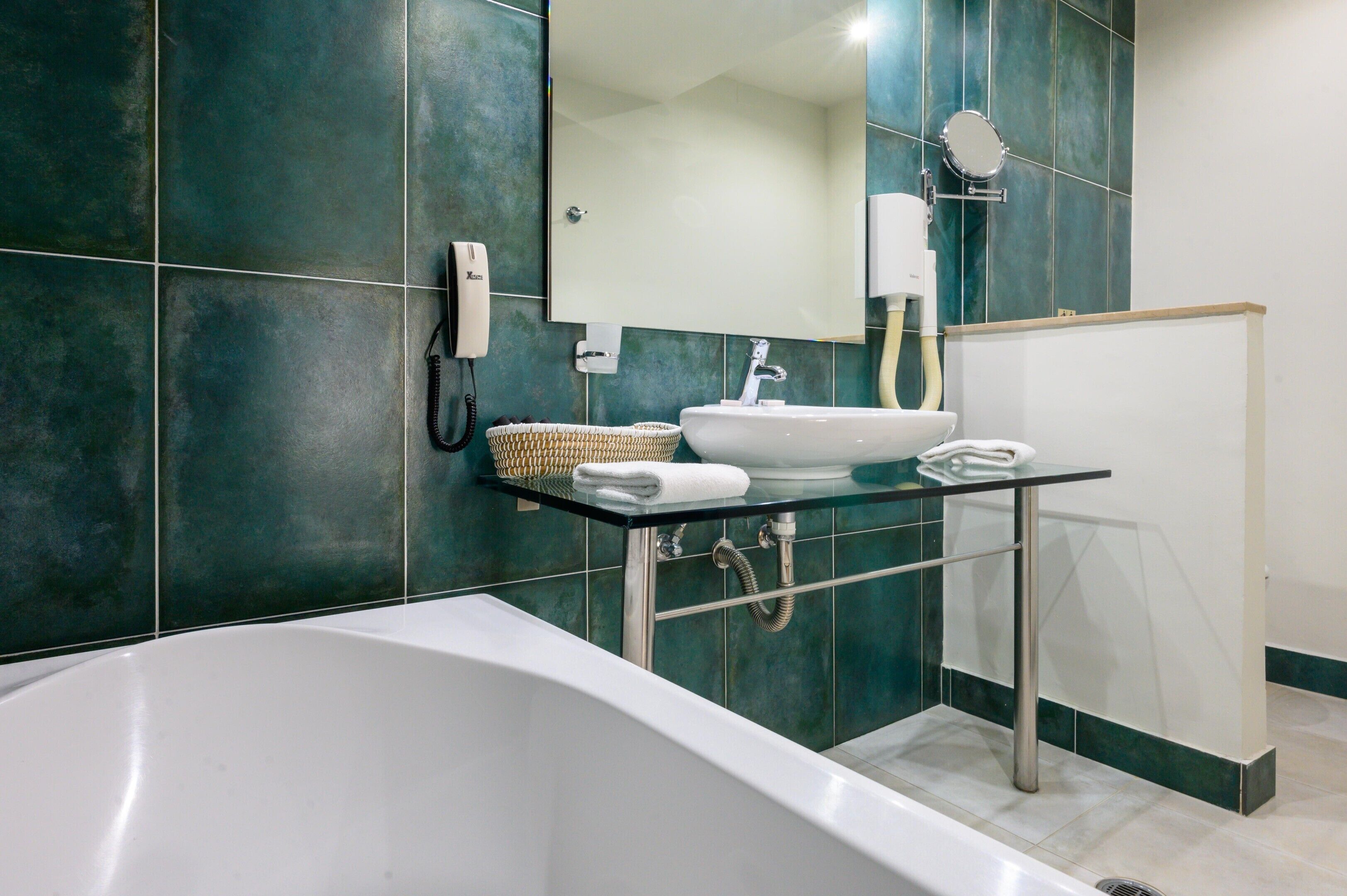A modern bathroom with a bathtub, a sink with a mirror, and a towel rack.