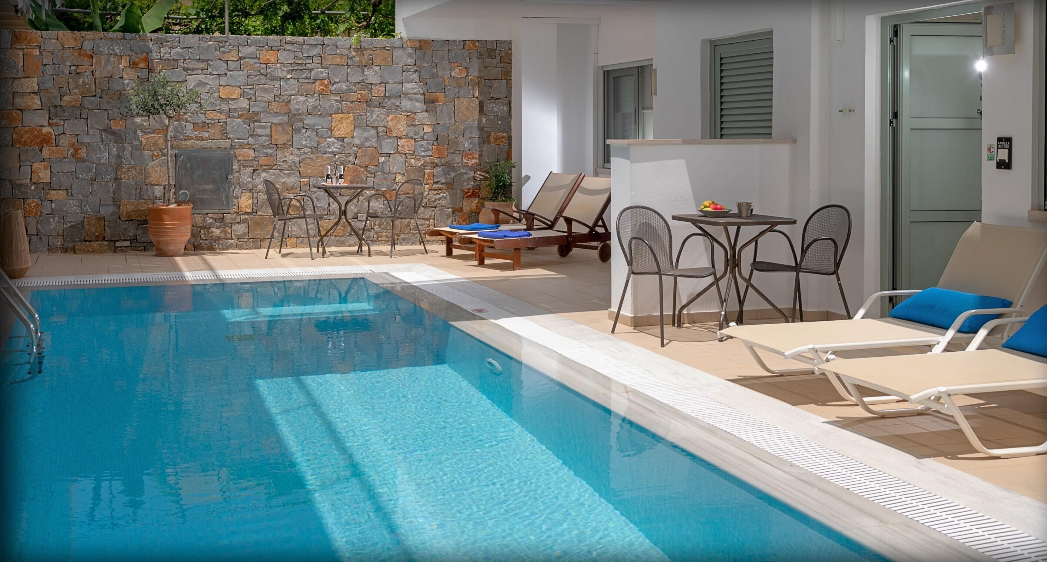Una piscina amb gandules i una paret de pedra.