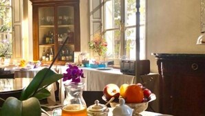 Une table de petit-déjeuner avec divers aliments, une carafe de jus d’orange et une tasse de café.