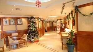 A lobby with a Christmas tree, a reception desk, and a "No Smoking" sign. - Panorama Deira (Dubai)
