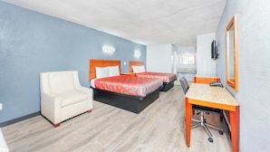 A hotel room with two beds, a desk, a chair, and a mirror. - Executive Inn of Hondo (Hondo)