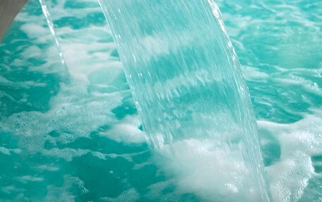 A water feature with a curved structure and a pool.
