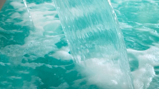 A water feature with a curved structure and a pool. - Occidental Aranjuez (Aranjuez)
