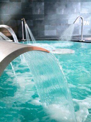 A water feature with a curved structure and a pool. - Occidental Aranjuez (Aranjuez)
