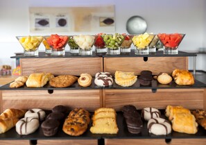 Fresh fruit and baked goods are artfully arranged on a tiered display.