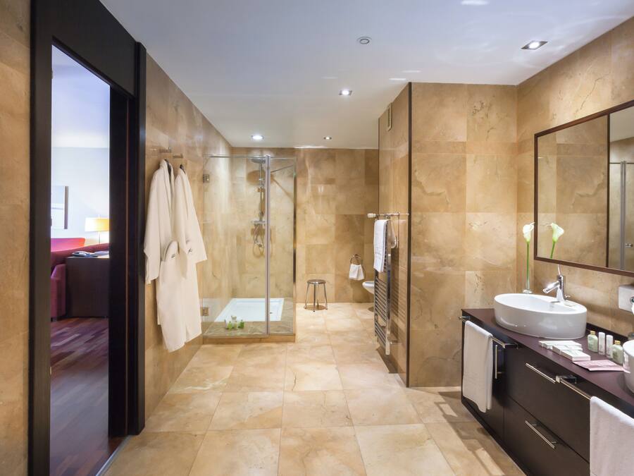 A modern bathroom with a glass-enclosed shower, two sinks, and a large mirror.