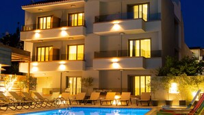 A multi-story hotel with a swimming pool, outdoor seating, and balconies. - Bourtzi Hotel (Skiathos)