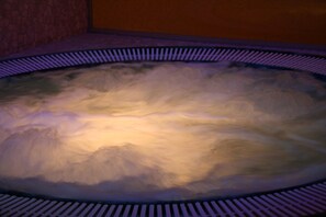Un jacuzzi circular con un interior texturizado y un borde estampado.